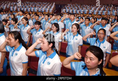 (180524) -- QINGDAO, 24 maggio 2018 -- i volontari prestano giuramento durante una cerimonia di lancio del programma di volontariato per il prossimo vertice dell'Organizzazione di cooperazione di Shanghai (SCO) a Qingdao, nella provincia dello Shandong della Cina orientale, il 24 maggio 2018. Circa 2.000 volontari offriranno servizi quali assistenza all'arrivo e alla partenza degli ospiti, traduzione e richieste mediatiche durante il 18° vertice della SCO. ) (Wyl) CHINA-QINGDAO-SCO-SUMMIT-VOLONTARIATO (CN) LixZiheng PUBLICATIONxNOTxINxCHN Foto Stock