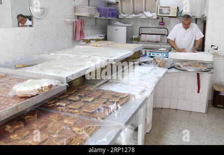 (180605) -- TRIPOLI, 5 giugno 2018 -- Uno chef rende dolce al-Shmisa a Tripoli, Libano, 4 giugno 2018. Il dolce al-Shmisa o ciambella cremosa è uno dei dolci popolari che si possono trovare solo in Libano a Tripoli. Questo tipo di dolce è fatto solo dalla famiglia al-Haddad i cui figli hanno ereditato questa professione per decenni. ) (lrz) LEBANON-TRIPOLI-CREAM DONUT Khalid PUBLICATIONxNOTxINxCHN Foto Stock