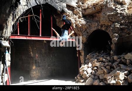 Bilder des Tages (180617) -- ALEPPO, 17 giugno 2018 -- Un giovane giocatore di parkour siriano esegue un backflip alto dalle sbarre di un vecchio cancello nella parte in gran parte danneggiata della città di Aleppo, nel nord della Siria, l'8 giugno 2018. Con le loro acrobazie mozzafiato e salti acrobatici, un gruppo di giovani siriani sta riportando vita nelle parti distrutte della città di Aleppo con la loro elettrizzante esibizione in Parkour. PER ANDARE CON la caratteristica: I giovani siriani rianimano la vita nelle vecchie rovine di Aleppo con un'elettrizzante prestazione di Parkour. ) (hy) SYRIA-ALEPPO-PARKOUR-FEATURE AmmarxSafarjalani PUBLICATIONxNOTxINxCHN Foto Stock