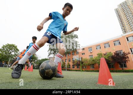 (180621) -- HANDAN, 21 giugno 2018 -- gli studenti frequentano la formazione di calcio presso la scuola elementare Guangmingnan di Handan, nella provincia di Hebei, nella Cina settentrionale, 21 giugno 2018. Gli studenti di diverse parti della Cina si sono divertiti a giocare a calcio mentre la Coppa del mondo FIFA 2018 continua in Russia. ) (mp) CHINA-STUDENTS-FOOTBALL (CN) HaoxQunying PUBLICATIONxNOTxINxCHN Foto Stock