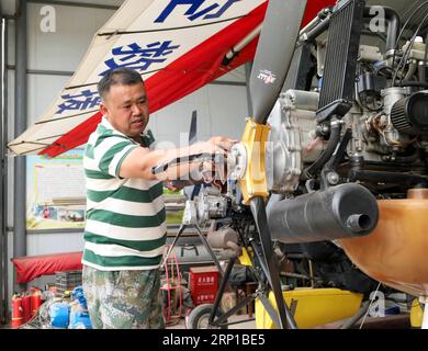 (180623) -- YINCHUAN, 23 giugno 2018 -- Liu Yibing pulisce un deltaplano motorizzato presso il suo Aero club nella contea di Helan della città di Yinchuan, regione autonoma Ningxia Hui della Cina nord-occidentale, 20 giugno 2018. Liu Yibing, 46 anni, è nata in una famiglia contadina. All'età di 17 anni, fu ispirato a costruire un aereo super leggero da solo dopo aver letto una rivista di aviazione. Trascorse tutto il suo tempo libero nella ricerca e nell'autoapprendimento per assemblare gli aerei dopo aver finito il lavoro sul campo. Ottenne con successo una licenza attraverso il dipartimento nazionale dell'aviazione e fece il suo primo volo nel 1996. Liu ha partecipato a dozzine di fligh Foto Stock