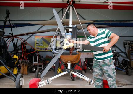 (180623) -- YINCHUAN, 23 giugno 2018 -- Liu Yibing pulisce un deltaplano motorizzato presso il suo Aero club nella contea di Helan della città di Yinchuan, regione autonoma Ningxia Hui della Cina nord-occidentale, 20 giugno 2018. Liu Yibing, 46 anni, è nata in una famiglia contadina. All'età di 17 anni, fu ispirato a costruire un aereo super leggero da solo dopo aver letto una rivista di aviazione. Trascorse tutto il suo tempo libero nella ricerca e nell'autoapprendimento per assemblare gli aerei dopo aver finito il lavoro sul campo. Ottenne con successo una licenza attraverso il dipartimento nazionale dell'aviazione e fece il suo primo volo nel 1996. Liu ha partecipato a dozzine di fligh Foto Stock