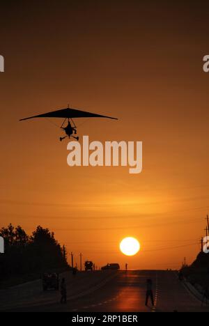 (180623) -- YINCHUAN, 23 giugno 2018 () -- la foto del file mostra Liu Yibing che vola su un deltaplano motorizzato all'alba. Liu Yibing, 46 anni, è nata in una famiglia contadina. All'età di 17 anni, fu ispirato a costruire un aereo super leggero da solo dopo aver letto una rivista di aviazione. Trascorse tutto il suo tempo libero nella ricerca e nell'autoapprendimento per assemblare gli aerei dopo aver finito il lavoro sul campo. Ottenne con successo una licenza attraverso il dipartimento nazionale dell'aviazione e fece il suo primo volo nel 1996. Liu ha partecipato a dozzine di competizioni di volo e ha iniziato a impegnarsi in tentativi di business da allora. Nel 2010, Liu es Foto Stock