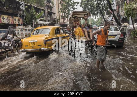 (180626) -- CALCUTTA, 26 giugno 2018 -- Un estrattore manuale per risciò trasporta i passeggeri attraverso strade allagate dopo una forte pioggia a Calcutta, India, il 26 giugno 2018. ) (lrz) INDIA-CALCUTTA-INONDAZIONE TumpaxMondal PUBLICATIONxNOTxINxCHN Foto Stock