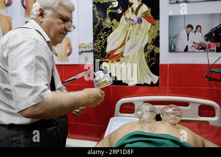 (180627) -- BAGHDAD, 27 giugno 2018 -- Sabah al-Mustwfi pratica la cup therapy su un paziente nella sua clinica privata a Baghdad, capitale dell'Iraq, il 14 giugno 2018. PER ANDARE CON caratteristica: Medico iracheno offre la medicina tradizionale cinese a Baghdad in mezzo al deterioramento della situazione sanitaria ) (zjl) KhalilxDawood PUBLICATIONxNOTxINxCHN Foto Stock