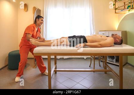 Massaggiatrice femminile che fa un massaggio ad un uomo Foto Stock
