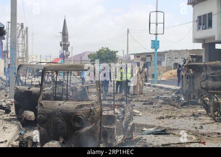 (180707) -- MOGADISCIO, 7 luglio 2018 -- foto scattata il 7 luglio 2018 mostra i motori che bruciano sul luogo di un'esplosione a Mogadiscio, Somalia. Almeno 12 persone sono state uccise e 17 altre ferite in gemelle esplosioni nella capitale somala Mogadiscio sabato, ha detto la polizia. ) (wtc) SOMALIA-MOGADISCIO-BLASTS FaisalxIsse PUBLICATIONxNOTxINxCHN Foto Stock