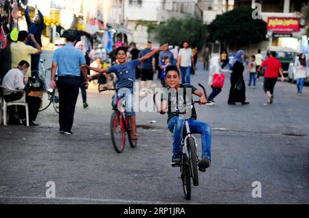 (180710) -- DARAA, 10 luglio 2018 -- due ragazzi cavalcano in bicicletta per strada nella capitale della provincia di Daraa, nel sud della Siria, il 9 luglio 2018. Le persone rimasero nelle loro case fino a quando non erano sicure di un accordo raggiunto venerdì tra l'esercito siriano e i ribelli per risolvere la situazione nella provincia meridionale di Daraa. Dal 19 giugno l'esercito siriano è impegnato in una campagna su vasta scala a Daraa per riconquistare Daraa da vari gruppi ribelli, compresi quelli ultra-radicali. L'esercito ha assunto il controllo di oltre il 72% di Daraa attraverso azioni militari e riconciliazioni con i ribelli, secondo il Foto Stock