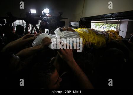 (180714) -- GAZA, 14 luglio 2018 -- lutti e parenti portano il corpo del quindicenne palestinese Othman rami Halles, durante il suo funerale nella parte orientale della città di Gaza il 14 luglio 2018. Il ragazzo è stato ucciso venerdì durante gli scontri tra manifestanti palestinesi e soldati israeliani nella Striscia di Gaza orientale vicino al confine con Israele, con altri 25 feriti, hanno detto medici locali. )(yg) MIDEAST-GAZA-FUNERAL Stringer PUBLICATIONxNOTxINxCHN Foto Stock