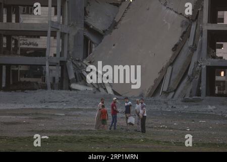 (180714) -- GAZA, 14 luglio 2018 -- i palestinesi si trovano vicino al sito dove un edificio è stato danneggiato da un attacco aereo israeliano nella città di Gaza, il 14 luglio 2018. Il Ministero della salute palestinese a Gaza ha detto che due bambini palestinesi sono stati uccisi e 14 feriti nell'ultimo attacco aereo israeliano di sabato pomeriggio a Gaza. ) MIDEAST-GAZA-AIRSTRIKE WissamxNassar PUBLICATIONxNOTxINxCHN Foto Stock