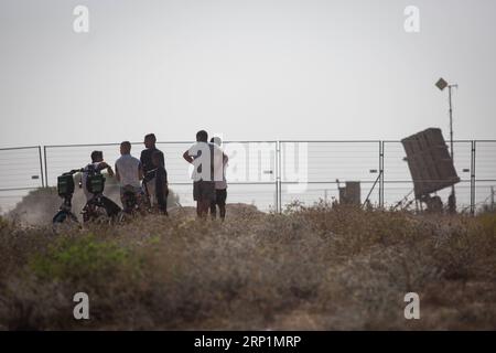 (180714) -- NAHAL OZ, 14 luglio 2018 -- la gente si trova vicino a un sistema di difesa aerea Iron Dome vicino a Kibbutz Nahal Oz, il 14 luglio 2018. Sabato pomeriggio le forze israeliane hanno condotto la terza ondata di attacchi contro obiettivi militanti nella Striscia di Gaza, mentre i razzi provenienti dal territorio isolato sono stati continuamente lanciati in Israele. MIDEAST-NAHAL OZ-GAZA-ATTACK JINI PUBLICATIONXNOTXINXCHN Foto Stock