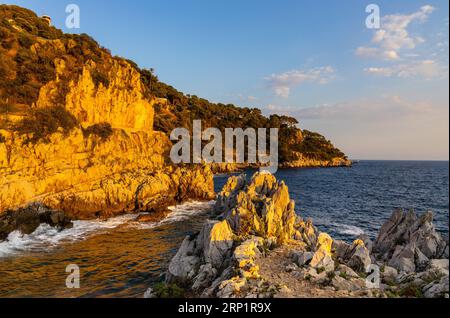 Scogliere e scogliere, paesaggio al tramonto di Cap Ferrat cape che ospita Saint-Jean-Cap-Ferrat, località turistica sulla Costa Azzurra del Mar Mediterraneo Foto Stock