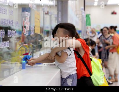 (180726) -- SHANGHAI, 26 luglio 2018 -- Un ragazzo ha il suo campione di sangue prelevato presso l'ospedale pediatrico dell'Università di Fudan nella Cina orientale di Shanghai, 26 luglio 2018. L'Ufficio Meteorologico di Shanghai ha emesso un allarme arancione per le alte temperature il giovedì, in quanto sono previsti circa 37 gradi Celsius nel comune. ) (Hxy) CHINA-SHANGHAI-HEAT-HOSPITAL (CN) LiuxYing PUBLICATIONxNOTxINxCHN Foto Stock