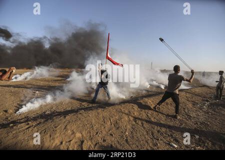 (180810) -- GAZA, 10 agosto 2018 -- Un manifestante palestinese usa una fionda per lanciare pietre contro le truppe israeliane durante gli scontri sul confine tra Gaza e Israele, a est della città di Gaza, il 10 agosto 2018. Due palestinesi, uno dei quali era medico, sono stati uccisi, e 307 palestinesi venerdì sono stati feriti in scontri vicino al confine tra Gaza e Israele, secondo il rapporto del Ministero della salute di Gaza. ) MIDEAST-GAZA-CLASH WissamxNassar PUBLICATIONxNOTxINxCHN Foto Stock