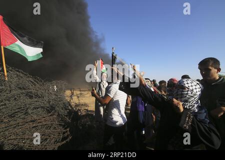 (180810) -- GAZA, 10 agosto 2018 -- Una donna palestinese usa una fionda per lanciare pietre contro le truppe israeliane durante gli scontri sul confine tra Gaza e Israele, a est della città meridionale di Khan Younis, nella Striscia di Gaza, il 10 agosto 2018. Due palestinesi, uno dei quali era medico, sono stati uccisi, e 307 palestinesi venerdì sono stati feriti in scontri vicino al confine tra Gaza e Israele, secondo il rapporto del Ministero della salute di Gaza. ) MIDEAST-GAZA-CLASH KhaledxOmar PUBLICATIONxNOTxINxCHN Foto Stock