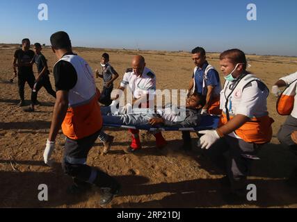 (180810) -- GAZA, 10 agosto 2018 -- i medici palestinesi trasportano un uomo ferito durante gli scontri con le truppe israeliane sul confine tra Gaza e Israele, a est della città meridionale di Khan Younis, nella Striscia di Gaza, il 10 agosto 2018. Due palestinesi, uno dei quali era medico, sono stati uccisi, e 307 palestinesi venerdì sono stati feriti in scontri vicino al confine tra Gaza e Israele, secondo il rapporto del Ministero della salute di Gaza. ) MIDEAST-GAZA-CLASH KhaledxOmar PUBLICATIONxNOTxINxCHN Foto Stock