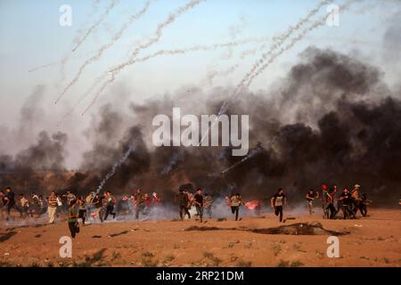 (180810) -- GAZA, 10 agosto 2018 () -- i manifestanti palestinesi corrono per coprire le bombole di gas lacrimogeni sparate dalle truppe israeliane durante gli scontri sul confine tra Gaza e Israele, a est della città di Gaza, il 10 agosto 2018. Due palestinesi, uno dei quali era medico, sono stati uccisi, e 307 palestinesi venerdì sono stati feriti negli scontri vicino al confine tra Gaza e Israele, secondo il rapporto del Ministero della salute di Gaza. () MIDEAST-GAZA-CLASHES Xinhua PUBLICATIONxNOTxINxCHN Foto Stock