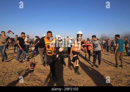 (180810) -- GAZA, 10 agosto 2018 -- i medici palestinesi trasportano un uomo ferito durante gli scontri con le truppe israeliane sul confine tra Gaza e Israele, a est della città meridionale di Khan Younis, nella Striscia di Gaza, il 10 agosto 2018. Due palestinesi, uno dei quali era medico, sono stati uccisi, e 307 palestinesi venerdì sono stati feriti in scontri vicino al confine tra Gaza e Israele, secondo il rapporto del Ministero della salute di Gaza. ) MIDEAST-GAZA-CLASH KhaledxOmar PUBLICATIONxNOTxINxCHN Foto Stock