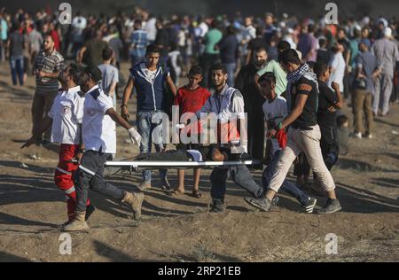 (180810) -- GAZA, 10 agosto 2018 -- i medici palestinesi trasportano un uomo ferito durante gli scontri con le truppe israeliane sul confine tra Gaza e Israele, a est della città di Gaza, il 10 agosto 2018. Due palestinesi, uno dei quali era medico, sono stati uccisi, e 307 palestinesi venerdì sono stati feriti in scontri vicino al confine tra Gaza e Israele, secondo il rapporto del Ministero della salute di Gaza. ) MIDEAST-GAZA-CLASH WissamxNassar PUBLICATIONxNOTxINxCHN Foto Stock