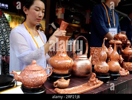 (180811) -- SHANGHAI, 11 agosto 2018 (Xinhua) -- artwares locali sono visti alla mostra d'arte popolare dello Yunnan al Giardino Yuyuan nella Shanghai orientale della Cina, 10 agosto 2018. La mostra è iniziata qui il venerdì e mostra danze popolari, artwares locali e paesaggi dalla città di Qujing, nella provincia dello Yunnan. (Xinhua/Liu Ying)(gxn) CHINA-SHANGHAI-YUNNAN-FOLR ART EXHIBITION (CN) PUBLICATIONxNOTxINxCHN Foto Stock