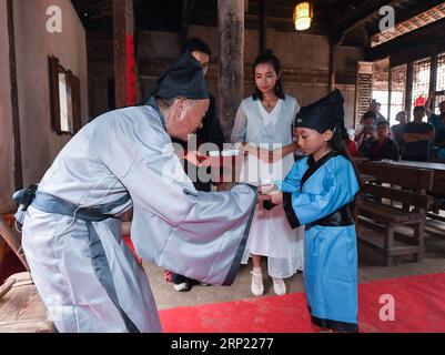 (180812) -- CHANGXING, 12 agosto 2018 (Xinhua) -- Uno studente serve tè a un insegnante durante una lezione tradizionale in una vecchia scuola privata nel villaggio di Zhongshan nella contea di Changxing, nella provincia di Zhejiang nella Cina orientale, 12 agosto 2018. (Xinhua/Xu Yu) CHINA-ZHEJIANG-CHANGXING-TRADITIONAL CLASS (CN) PUBLICATIONxNOTxINxCHN Foto Stock