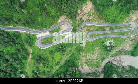 (180813) -- GYIRONG, 13 agosto 2018 -- foto aerea scattata il 12 agosto 2018 mostra una tortuosa strada di montagna dell'autostrada del passo Gyirong nella contea di Gyirong della città di Xigaze, nella regione autonoma del Tibet della Cina sud-occidentale. L'autostrada del passo Gyirong, una sezione di 94 chilometri della National Highway 216, è un'importante via commerciale che collega la Cina e il Nepal. La strada è stata pesantemente colpita dal devastante terremoto in Nepal nell'aprile 2015. Ora la strada ha ripreso vitalità e ha preso un nuovo aspetto dopo anni di riparazione e ristrutturazione, mentre il volume annuale del commercio del porto di Gyirong è quasi cresciuto di sette volte rispetto al pos Foto Stock