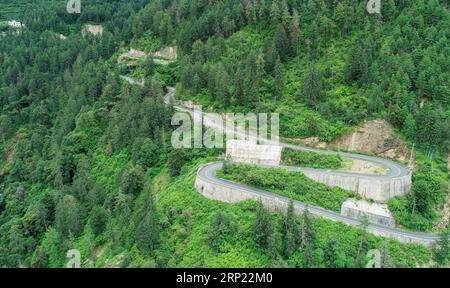 (180813) -- GYIRONG, 13 agosto 2018 -- foto aerea scattata il 12 agosto 2018 mostra una tortuosa strada di montagna dell'autostrada del passo Gyirong nella contea di Gyirong della città di Xigaze, nella regione autonoma del Tibet della Cina sud-occidentale. L'autostrada del passo Gyirong, una sezione di 94 chilometri della National Highway 216, è un'importante via commerciale che collega la Cina e il Nepal. La strada è stata pesantemente colpita dal devastante terremoto in Nepal nell'aprile 2015. Ora la strada ha ripreso vitalità e ha preso un nuovo aspetto dopo anni di riparazione e ristrutturazione, mentre il volume annuale del commercio del porto di Gyirong è quasi cresciuto di sette volte rispetto al pos Foto Stock