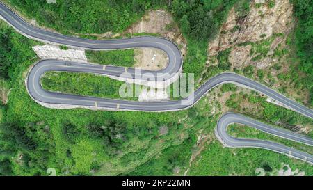 (180813) -- GYIRONG, 13 agosto 2018 -- foto aerea scattata il 12 agosto 2018 mostra una tortuosa strada di montagna dell'autostrada del passo Gyirong nella contea di Gyirong della città di Xigaze, nella regione autonoma del Tibet della Cina sud-occidentale. L'autostrada del passo Gyirong, una sezione di 94 chilometri della National Highway 216, è un'importante via commerciale che collega la Cina e il Nepal. La strada è stata pesantemente colpita dal devastante terremoto in Nepal nell'aprile 2015. Ora la strada ha ripreso vitalità e ha preso un nuovo aspetto dopo anni di riparazione e ristrutturazione, mentre il volume annuale del commercio del porto di Gyirong è quasi cresciuto di sette volte rispetto al pos Foto Stock