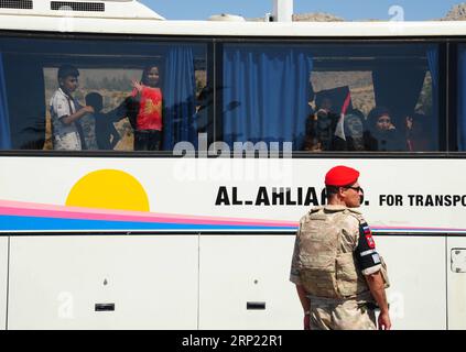 (180814) -- DAMASCO, 14 agosto 2018 -- bambini siriani agitano le mani come un ufficiale di polizia militare russo che sta di guardia al confine tra Siria e Libano di Jdaidet Yabous il 13 agosto 2018. Circa 150 rifugiati siriani sono tornati nel loro paese lunedì da Shabaa in Libano, hanno riferito i media locali. Questo è il quarto gruppo di rifugiati siriani che ritornano nella loro patria da Shabaa. )(gj) SIRIA-DAMASCO-RIFUGIATI-RITORNO-DAL-LIBANO AmmarxSafarjalani PUBLICATIONxNOTxINxCHN Foto Stock