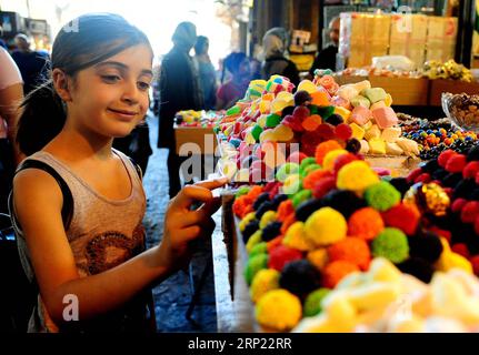 (180814) -- DAMASCO, 14 agosto 2018 -- Una ragazza acquista caramelle da un negozio di dolci nell'antico mercato di Buzoriyeh nella città vecchia di Damasco, Siria, il 13 agosto 2018. La gente di Damasco ha iniziato a fare shopping per la festa di Eid al-Adha che sarà osservata la prossima settimana dai musulmani di tutto il mondo. )(gj) SYRIA-DAMASCO-EID-AL ADHA-PREPARAZIONI AmmarxSafarjalani PUBLICATIONxNOTxINxCHN Foto Stock