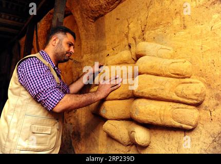 (180815) -- DAMASCO, 15 agosto 2018 -- Un artista siriano lavora per perfezionare una scultura sulla parete di un tunnel sotterraneo precedentemente gestito dai ribelli nel quartiere di Jobar, nella campagna orientale di Ghouta, nella capitale Damasco, il 14 agosto 2018. Gli artisti siriani hanno trasformato i tunnel in una galleria di sculture dopo la sconfitta dei ribelli a Ghouta orientale lo scorso aprile. )(gj) SYRIA-DAMASCO-MILITANT TUNNELS-SCULTPURE GALLARY AmmarxSafarjalani PUBLICATIONxNOTxINxCHN Foto Stock