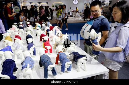 (180825) -- SHANGHAI, agosto 25, 2018 -- i visitatori guardano vestiti per cani da compagnia alla 21a Fiera Asia degli animali domestici a Shanghai, Cina orientale, agosto 25, 2018. La fiera PET si tiene qui dal 22 al 26 agosto. Oltre 1.300 espositori che hanno portato più di 16.000 marchi di articoli per animali domestici hanno partecipato alla fiera. ) (Hxy) CHINA-SHANGHAI-PET FAIR ASIA (CN) FangxZhe PUBLICATIONxNOTxINxCHN Foto Stock