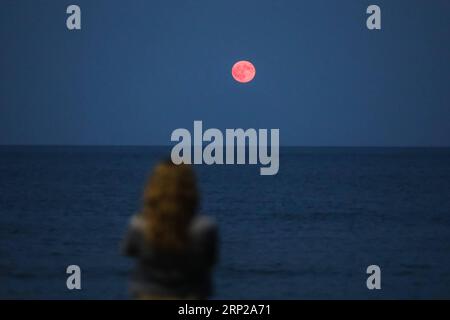 (180827) -- ATTICA, 27 agosto 2018 -- Una donna guarda la luna piena nel cielo sopra la spiaggia di Artemida, 25 chilometri ad est di Atene, Grecia, 26 agosto 2018. ) (dtf) GRECIA-ATTICA-FULL MOON LefterisxPartsalis PUBLICATIONxNOTxINxCHN Foto Stock