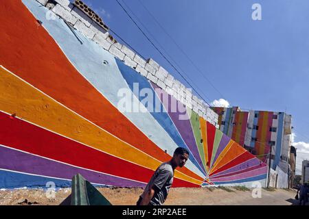 (180827) -- OUZAI, 27 agosto 2018 -- Un uomo cammina davanti a edifici con dipinti colorati a Ouzai, a sud di Beirut, Libano, il 26 agosto 2018. ) (Jmmn) LEBANON-OUZAI-BUILDINGS BilalxJawich PUBLICATIONxNOTxINxCHN Foto Stock