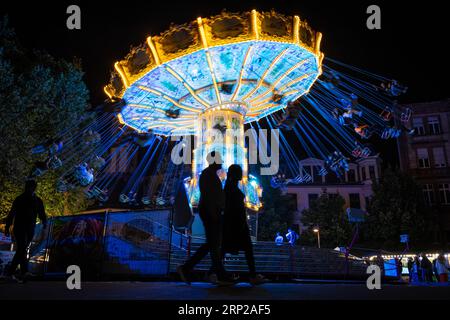 Le luci colorate della giostra al Mainfest brillano di sera. Il Mainfest sul Mainkai, Fahrtor e Roemerberg è uno dei più importanti di Francoforte Foto Stock