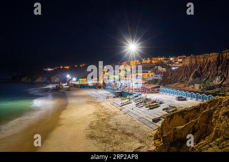 La spiaggia di Olhos de Agua, un ex villaggio di pescatori nell'Algarve portoghese nel distretto di Faro, vicino alla città di Albufeira, è illuminata Foto Stock