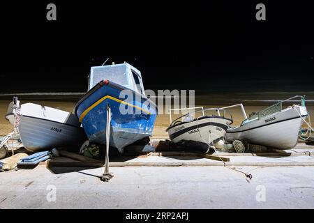 Diverse barche da pesca allineate l'una accanto all'altra sulla spiaggia di Olhos de Agua, un ex villaggio di pescatori nell'Algarve portoghese nel distretto Foto Stock