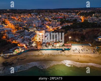 La spiaggia di Olhos de Agua, un ex villaggio di pescatori nell'Algarve portoghese nel distretto di Faro, vicino alla città di Albufeira, è illuminata Foto Stock