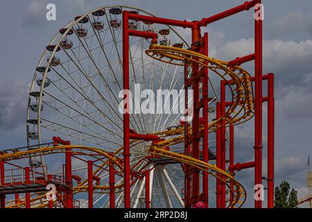 Nuvole scure sopra l'attrazione adrenalinica volare, dietro la ruota dei fiori, Prater, Vienna, Austria Foto Stock