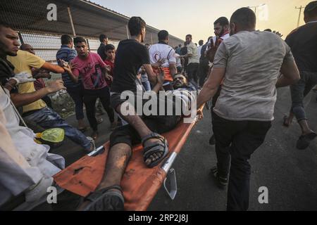 (180904) -- GAZA, 4 settembre 2018 -- manifestanti e medici palestinesi trasportano un uomo ferito durante gli scontri dopo una manifestazione all'attraversamento di Erez vicino al confine con Israele, nella parte settentrionale della Striscia di Gaza, il 4 settembre 2018. Centinaia di palestinesi hanno manifestato martedì pomeriggio nella Striscia di Gaza settentrionale contro la decisione degli Stati Uniti di fermare gli aiuti finanziari statunitensi all'Agenzia delle Nazioni Unite per il soccorso e il lavoro (UNRWA), testimoni oculari e media locali hanno riferito. ) MIDEAST-GAZA-DIMOSTRAZIONE WissamxNassar PUBLICATIONxNOTxINxCHN Foto Stock