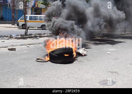 (180905) -- ADEN (YEMEN), 5 settembre 2018 -- Una strada principale è bloccata con pneumatici in fiamme durante una protesta ad Aden, Yemen, il 5 settembre 2018. Le dimostrazioni che richiedevano riforme economiche aumentarono in tutte le province meridionali del paese controllate dal governo compresa la città portuale di Aden per il quarto giorno consecutivo. YEMEN-ADEN-PROTESTA MuradxAbdu PUBLICATIONxNOTxINxCHN Foto Stock