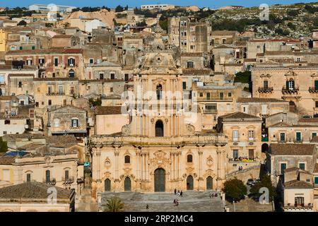 Il Duomo di San Giorgio, la chiesa di San Georgio, tutto intorno a case storiche color sabbia sulle colline, la città vecchia, Modica, la città barocca, l'angolo barocco Foto Stock