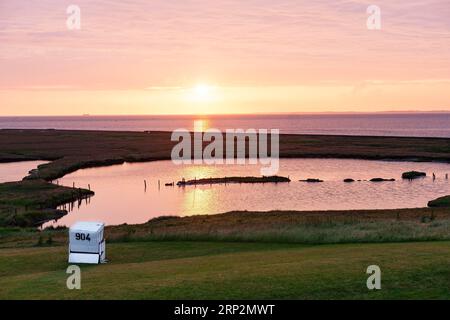 Una sdraio sul prato al tramonto su Hallig Langeness, Schleswig-Holstein, Germania Foto Stock