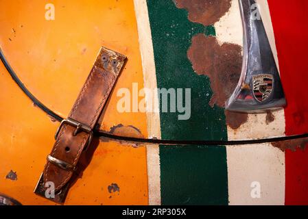 Dettaglio del cappuccio o della cinghia del cofano in pelle e emblema su una Porsche 356 C 1600 arancione del 1964 con livrea bandiera italiana Foto Stock