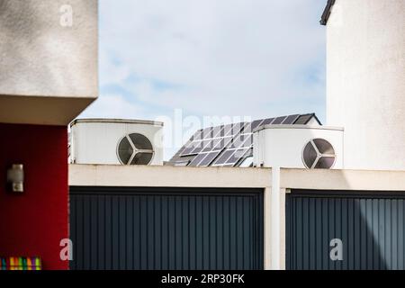 Pompa di calore su un tetto di garage di un nuovo sviluppo, sullo sfondo i pannelli solari sono montati sui tetti delle case, Monheim am Rhein, Renania settentrionale-Vestfalia Foto Stock