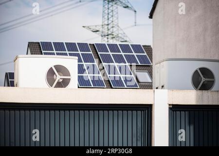 Pompa di calore su un tetto di garage di un nuovo sviluppo, sullo sfondo i pannelli solari sono montati sui tetti delle case, Monheim am Rhein, Renania settentrionale-Vestfalia Foto Stock