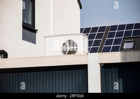 Pompa di calore su un tetto di garage di un nuovo sviluppo, sullo sfondo i pannelli solari sono montati sui tetti delle case, Monheim am Rhein, Renania settentrionale-Vestfalia Foto Stock