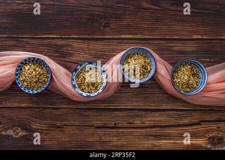 Alcune belle ciotole di porcellana blu piene di cereali per la colazione su un tavolo in legno Foto Stock