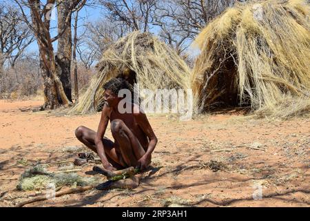 Un uomo San davanti alla sua capanna Foto Stock