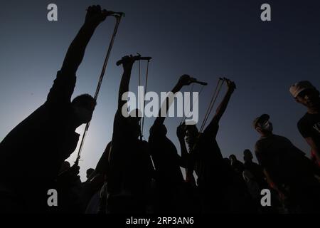 (180928) -- GAZA, 28 settembre 2018 -- i manifestanti palestinesi usano le fionde per lanciare pietre contro le truppe israeliane durante gli scontri sul confine tra Gaza e Israele, a est della città meridionale di Khan Younis nella Striscia di Gaza, il 28 settembre 2018. ) (wtc) MIDEAST-GAZA-CLASHES KhaledxOmar PUBLICATIONxNOTxINxCHN Foto Stock